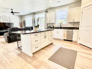 Kitchen featuring light hardwood / wood-style floors, white cabinets, dishwasher, and ceiling fan