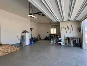 Garage with a garage door opener and white fridge