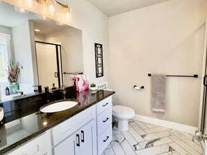 Bathroom featuring oversized vanity, toilet, and tile floors