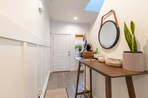 Hall with light LVP flooring and a skylight