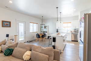 Living room featuring a notable chandelier, sink, and light LVP flooring