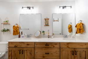 Bathroom featuring double vanity and toilet