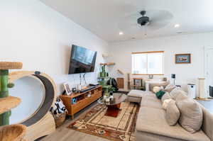 Living room featuring light LVP flooring and ceiling fan