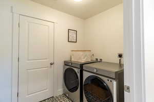 Laundry area with separate washer and dryer and light tile patterned floors