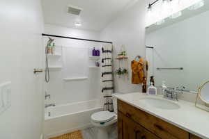 Full bathroom featuring vanity, shower / tub combo, tile patterned flooring, and toilet