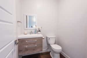 Bathroom featuring hardwood / wood-style flooring, vanity, and toilet