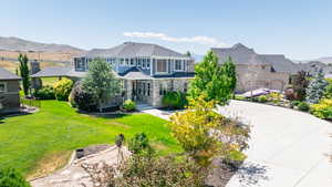 View of front of home with a front yard, a garage, and a mountain view