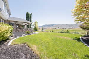 View of yard featuring a mountain view, ceiling fan, and a rural view