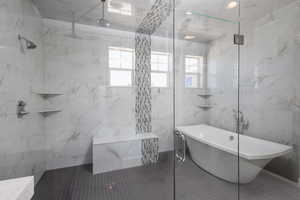 Bathroom with tile walls, tile floors, and shower with separate bathtub