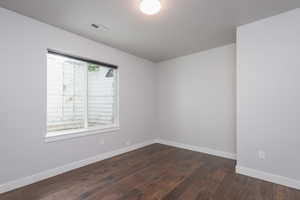 Spare room with dark hardwood / wood-style flooring