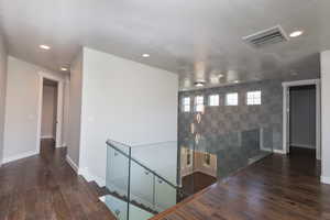 Corridor with dark hardwood / wood-style flooring