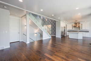 Unfurnished living room featuring dark hardwood / wood-style floors and sink