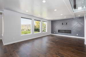 Unfurnished living room featuring dark hardwood / wood-style flooring and a fireplace