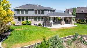 Back of house featuring a patio area and a lawn