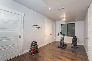 Exercise room with dark wood-type flooring