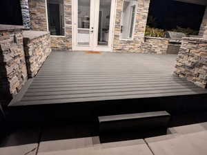 Wooden deck with french doors, a grill, and exterior kitchen