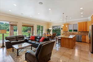 Tiled living room featuring plenty of natural light, ornamental molding, and sink