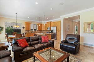 Living room featuring ornamental molding and light tile floors