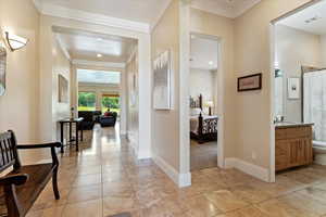 Hall with light tile floors and crown molding