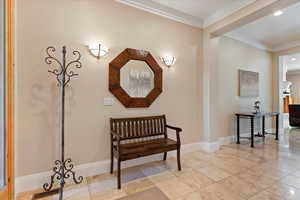 Hall featuring crown molding and light tile floors