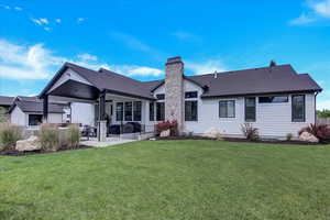 Rear view of property with a patio and a lawn