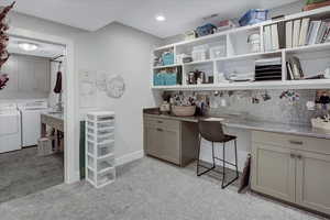 Carpeted office featuring sink and separate washer and dryer