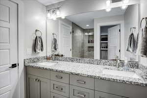 Bathroom with a shower with shower door and double sink vanity