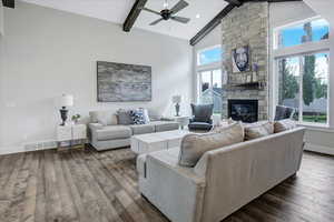 Living room with beamed ceiling, high vaulted ceiling, plenty of natural light, and dark wood-type flooring