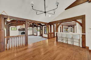 Dining room with lofted ceiling with beams, light hardwood / wood flooring, and a fireplace