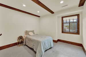 Bedroom featuring beamed ceiling and carpet floors