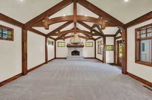 Unfurnished living room with carpet flooring and lofted ceiling