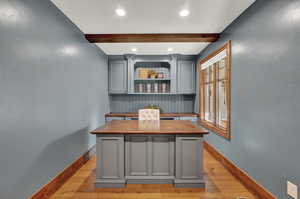 Office space featuring beam ceiling and wood flooring