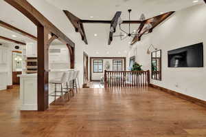 Unfurnished dining area with beam ceiling, plenty of natural light, a chandelier, and  hardwood flooring