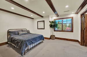 Bedroom with beamed ceiling and carpet flooring