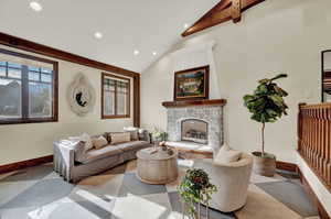 Living room with beamed ceiling, tile floors, high vaulted ceiling, and a fireplace