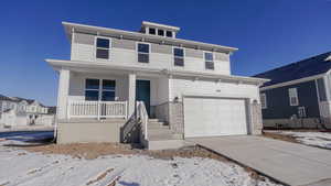 View of front facade with a porch and a garage