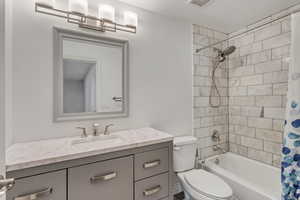 Full basement bathroom with large vanity and marble tile.