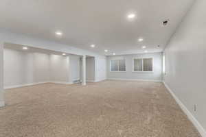 Basement media/game room with light carpet.