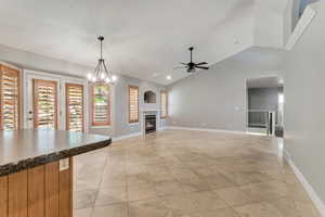 Unfurnished living room with vaulted ceiling and fireplace.