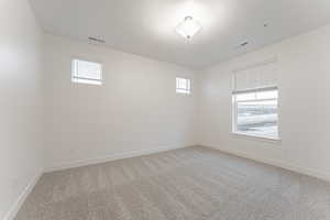 Carpeted spare room with a healthy amount of sunlight and a textured ceiling