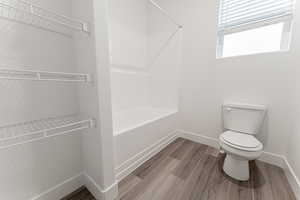 Bathroom with hardwood / wood-style flooring and toilet