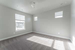 Unfurnished room with a textured ceiling and carpet floors