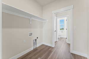 Washroom with hookup for a washing machine, hardwood / wood-style floors, and hookup for an electric dryer