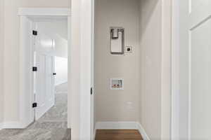 Clothes washing area with carpet flooring, hookup for a washing machine, and hookup for an electric dryer