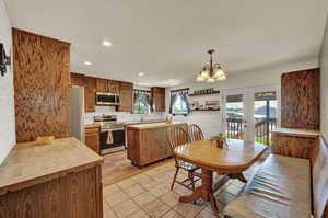 Kitchen with canned lighting, island, stainless steel finishes.