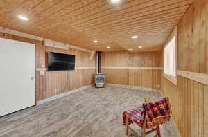 Family room with wood ceiling, wood walls, and a wood stove