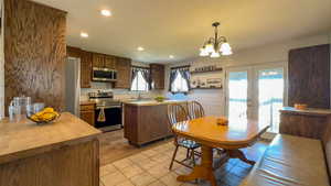 Kitchen with a wealth of natural light, appliances with stainless steel finishes, laminate wood floors and french doors.