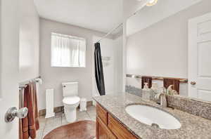 Main Bathroom featuring tile flooring, toilet, and vanity