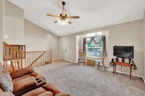 Sitting room with high vaulted ceiling, ceiling fan, and light carpet