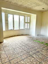 Unfurnished room with a healthy amount of sunlight and a textured ceiling